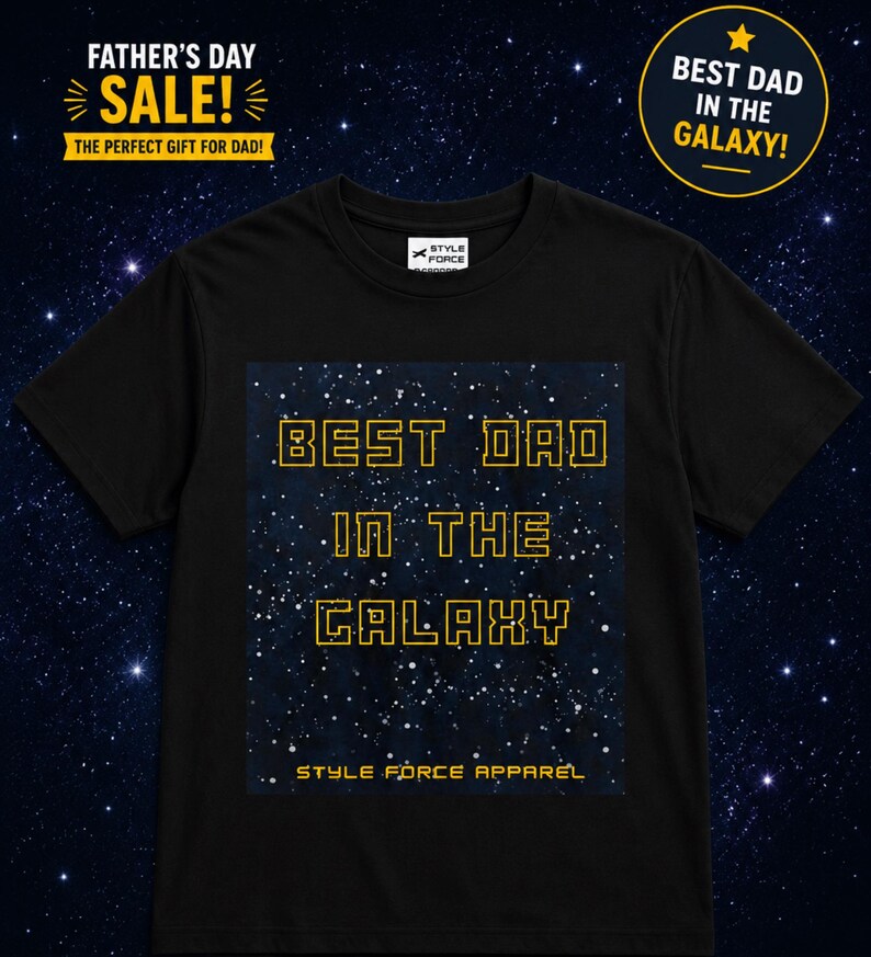 May include: A black short-sleeved t-shirt featuring a rectangular graphic of a starry night sky. The text "BEST DAD IN THE GALAXY" is printed in a yellow, blocky, outlined font, with "STYLE FORCE APPAREL" written in smaller yellow text below.
