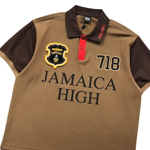 Front angled view of brown polo shirt with “Jamaica High” embroidery