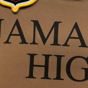 Detailed close-up of embroidered “Jamaica High” lettering