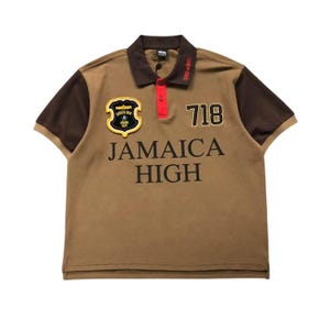 Front view of brown polo shirt with “Jamaica High” embroidery and patches