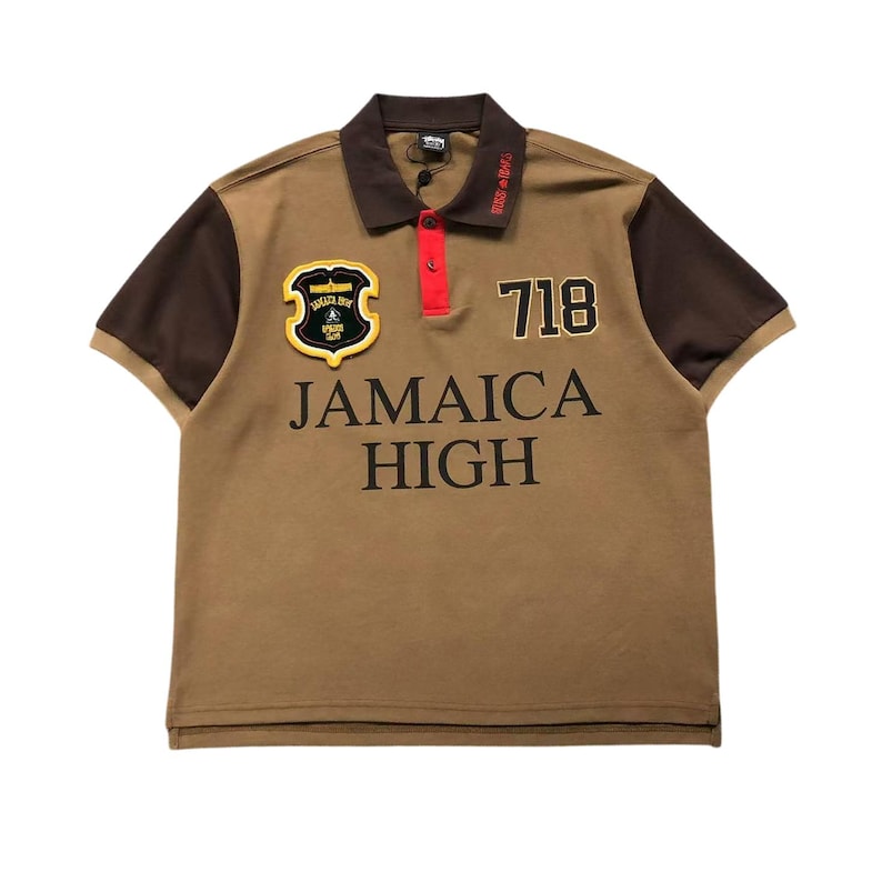 Front view of brown polo shirt with “Jamaica High” embroidery and patches