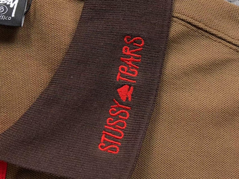 Close-up of sleeve embroidery with red text detail