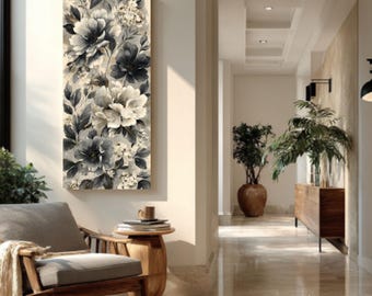 May include: A vertical floral canvas print featuring large, monochrome flowers in shades of gray and white. The artwork is displayed in a well-lit hallway, with a wooden chair and side table in the foreground. The overall aesthetic is modern and elegant.