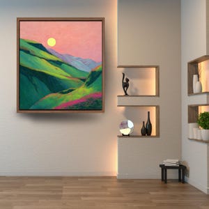 May include: A framed landscape painting depicts rolling green hills under a pink and yellow sky. The artwork features a vibrant color palette and a wooden frame, creating a serene and natural aesthetic.