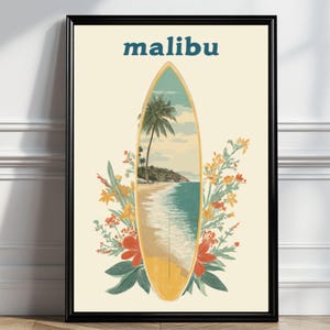 May include: Framed art print featuring a surfboard design with a beach scene inside. The word "malibu" is printed above the surfboard in blue. The surfboard is surrounded by colorful flowers and foliage, set against a cream background.