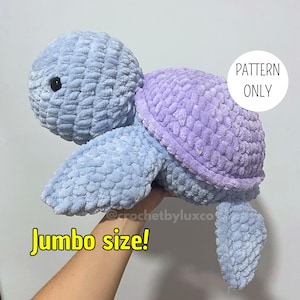 Puede incluir: Una tortuga de crochet hecha a mano, de tamaño grande, en tonos azules y morados. La tortuga tiene un aspecto texturizado y afelpado con una cabeza y extremidades azul claro, y un caparazón morado. El texto "PATTERN ONLY" es visible.