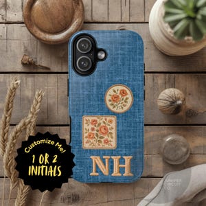 Puede incluir: Una funda de teléfono azul con textura de mezclilla con parches florales y las iniciales "NH". La funda presenta un módulo de cámara negro y el texto "Customize Me! 1 OR 2 INITIALS".