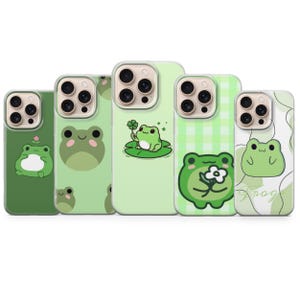 以下が含まれることがあります： さまざまな緑色のカエルのデザインが施された5つの携帯電話ケースのコレクション。ケースには、花、クローバー、シンプルなカエルの顔など、さまざまなカエルのイラストが描かれています。