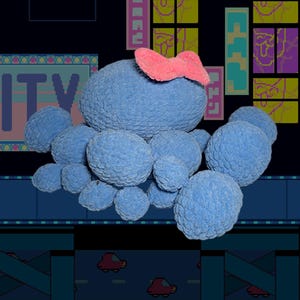 May include: A blue plush toy with a pink bow on top, surrounded by smaller blue plush spheres. The background features a pixelated cityscape with the word "CITY" and other pixelated elements.