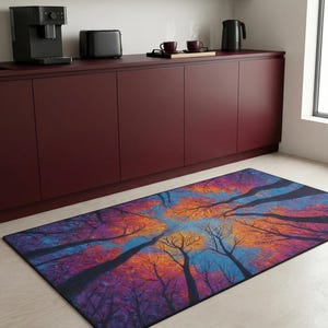 May include: A rectangular area rug featuring a vibrant, artistic depiction of trees reaching towards a blue sky. The rug showcases a colorful palette of orange, purple, and blue hues, creating a visually striking design.