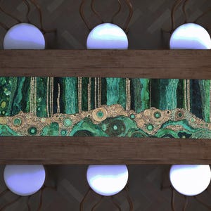 May include: Overhead view of a wooden dining table with six white, spherical chairs. The table features a green and gold decorative runner with an abstract design. The chairs have brown, curved backs.