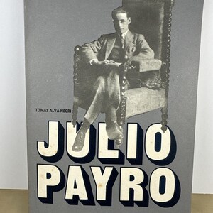 May include: A book cover with a grayscale image of a man seated in a large chair. The title "JULIO PAYRO" is prominently displayed in large, white, block letters with a black shadow. The cover also includes text in Spanish.