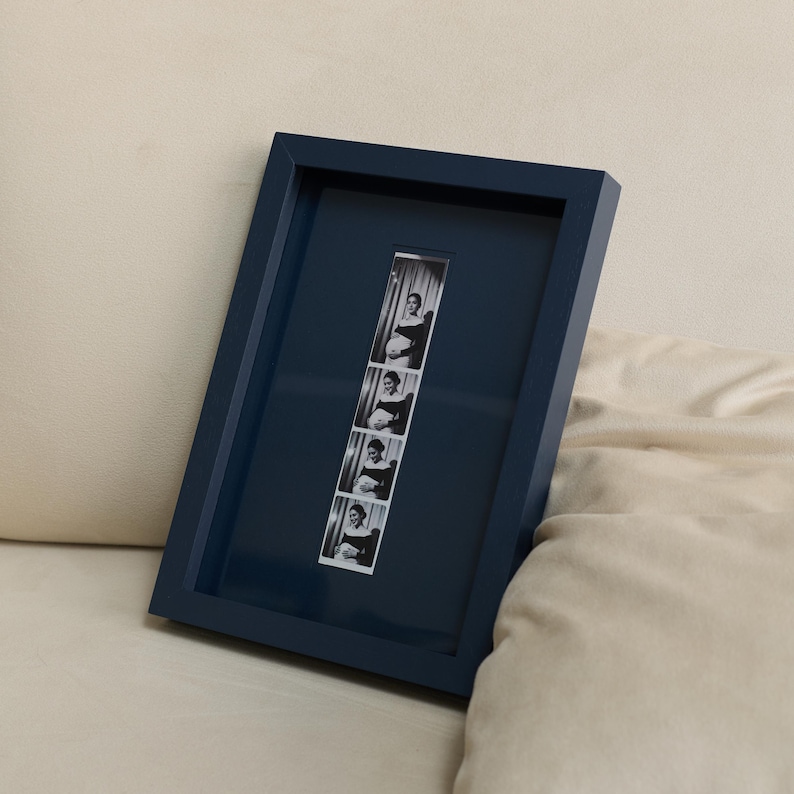 Navy blue personalized photobooth strip frame featuring a vertical black and white photo strip, styled as modern minimalist wall decor. Custom 9x13 inch picture frame designed for wedding photo booth memories, engagement photos, anniversary pictures, and meaningful keepsakes. Stylish personalized gift for couples, newlyweds, husbands, wives, friends, and family, perfect for weddings, anniversaries, Christmas, birthdays, Valentine's Day, and gallery wall displays.