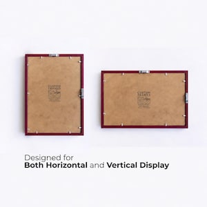 May include: Two rectangular picture frames with dark red borders and brown backing boards. Each frame features metal hanging hardware and a logo with the text CUSTOM FRAMES. The text below reads: Designed for Both Horizontal and Vertical Display.
