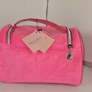 A slightly different angle of the pink velvet cosmetic bag resting on a white surface.
