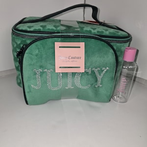 Puede incluir: Un juego de neceseres Juicy Couture verdes. El juego incluye una bolsa rectangular con asa, una bolsa frontal más pequeña con la palabra "JUICY" en pedrería y una botella transparente con tapón rosa.