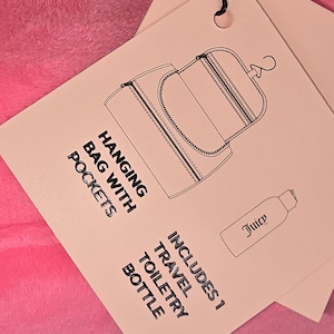 Close-up of a paper product tag detailing a hanging bag with pockets and an included toiletry bottle.