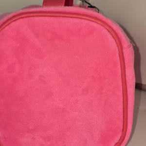 Close-up of the circular side panel of the pink velvet cosmetic case.
