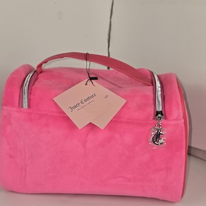 Side-angled view of the pink velvet makeup bag with paper tags hanging from the handle.