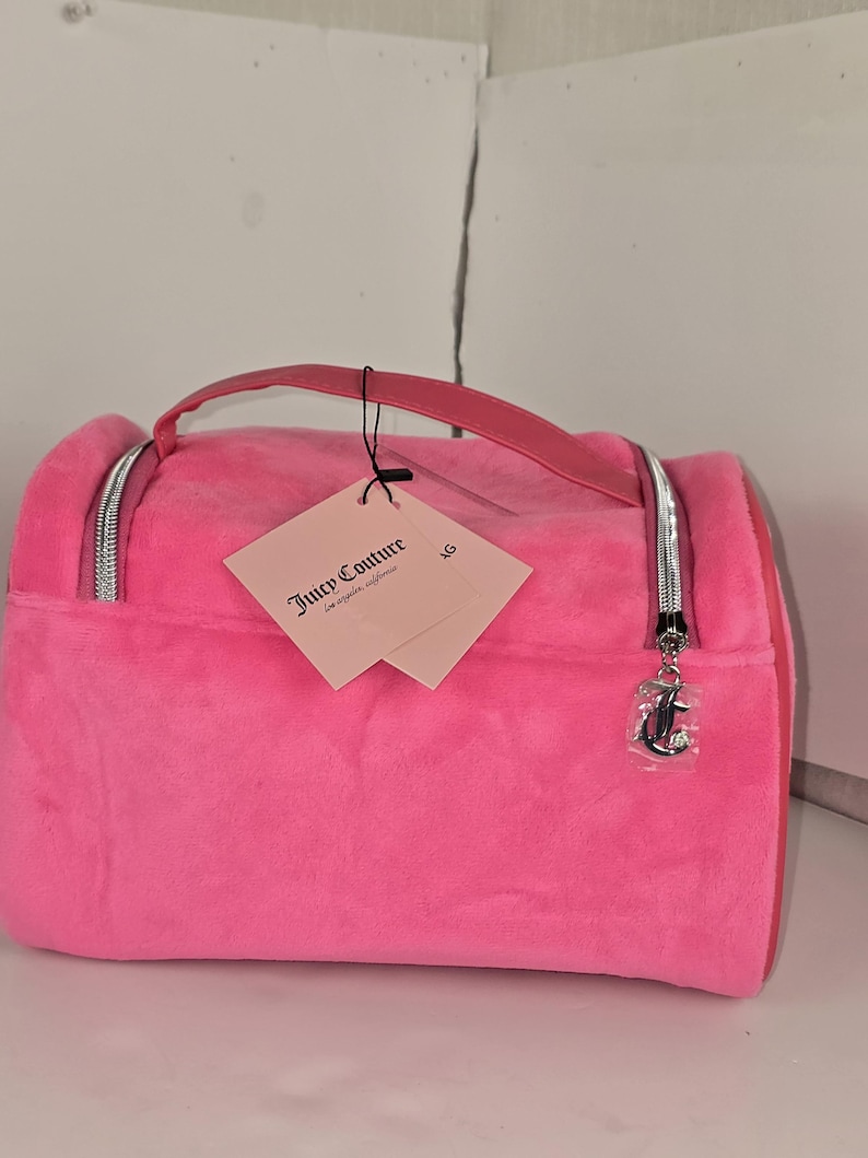 Side-angled view of the pink velvet makeup bag with paper tags hanging from the handle.