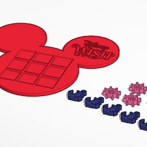 Puede incluir: Un objeto rojo con forma de Mickey Mouse con una cuadrícula de cuadrados y la palabra "WISH" en escritura cursiva. También hay varias piezas decorativas azules y rosas. Los artículos parecen estar impresos en 3D.
