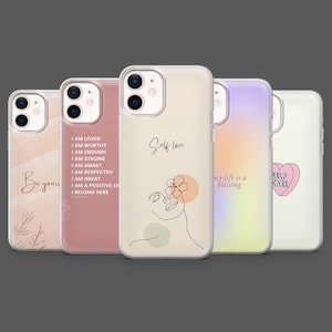 May include: Five phone cases with different designs and quotes. The cases are in shades of pink, peach, purple, and white. The cases feature motivational phrases and minimalist line art. They are designed to fit a smartphone.
