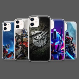 Op de afbeelding: Een verzameling van vijf telefoonhoesjes met ontwerpen geïnspireerd op de Transformers-franchise. De hoesjes tonen verschillende personages en het Autobot-symbool, met levendige kleuren en gedetailleerde illustraties. De hoesjes worden gepresenteerd tegen een grijze achtergrond.