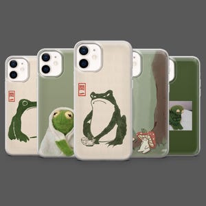 May include: A collection of phone cases featuring frog illustrations in various styles. The cases showcase a range of designs, including a frog with a bowl, a frog in a robe, and a frog silhouette. The cases have a clear, protective design.