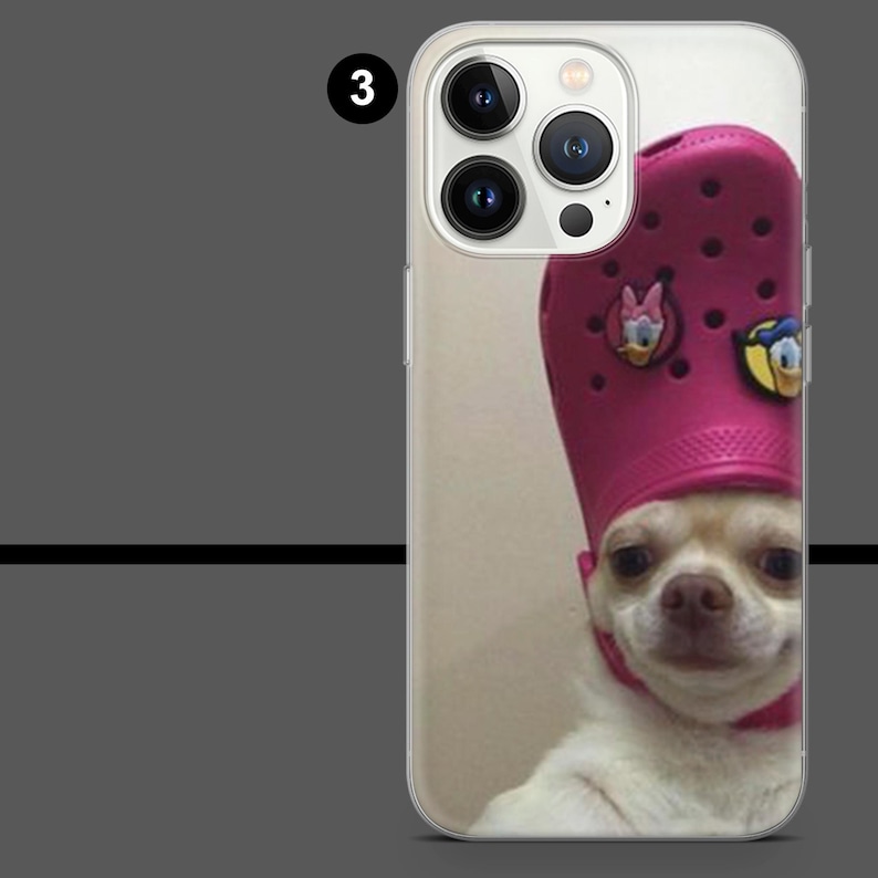 May include: Clear phone case featuring a chihuahua wearing a pink clog hat with Disney character charms. The dog has a light-colored coat and is looking at the camera.