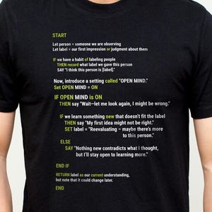 May include: Black t-shirt with white text detailing a thought process, starting with "START" and ending with "END." The text describes a method for open-mindedness and reevaluation. The shirt is a crew neck and is being worn.