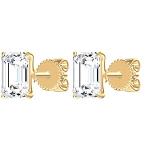 May include: A pair of stud earrings featuring emerald-cut clear gemstones set in yellow gold prongs. Each earring includes a matching yellow gold post and a textured, circular screw-back closure, showcasing a clean and polished metal finish.