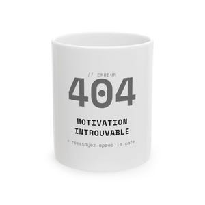 May include: A white ceramic mug featuring the grey text // ERREUR 404, followed by the black text MOTIVATION INTROUVABLE and the smaller text > réessayez après le café_. The design is centred on the front of the cylindrical drinking vessel.