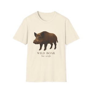 May include: A cream-coloured t-shirt displaying a detailed illustration of a wild boar. The boar is rendered in shades of brown and black, with the words "WILD BOAR" and "Sus scrofa" printed beneath the image in a dark brown font.