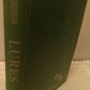May include: A green hardcover book with the title "LURES" printed in gold lettering on the spine.