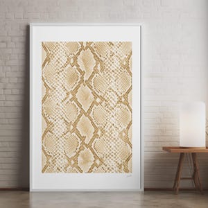 Puede incluir: Una lámina de arte mural rectangular vertical con un patrón repetitivo de piel de serpiente en tonos beige y crema. La lámina está enmarcada en un marco blanco fino, mostrando una textura detallada y escamosa que imita la piel de reptil.