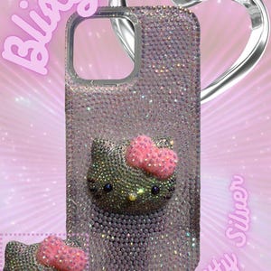 Puede incluir: Funda de tel&eacute;fono adornada con un dise&ntilde;o de Hello Kitty. La funda est&aacute; cubierta de pedrer&iacute;a plateada y presenta una cara de Hello Kitty en 3D con un lazo rosa. El fondo tiene el texto "Blixity" y "Hello Kitty Silver".