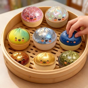 May include: A wooden steamer basket filled with eight colorful, smiling dumpling-shaped containers. The containers are in various colors, including pink, blue, green, gold, and silver. A hand reaches for one of the blue containers.