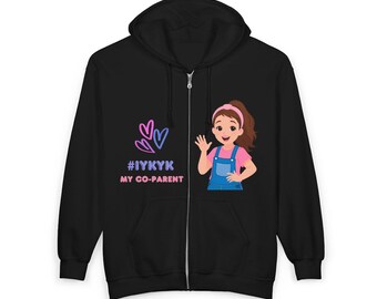 May include: Black zip-up hoodie with a cartoon illustration of a girl waving, wearing a pink top and blue dungarees. The hoodie also displays the text "#IYKYK MY CO-PARENT" with heart graphics in pink and blue.
