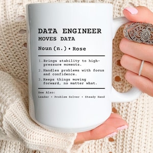 May include: White ceramic mug with the text "DATA ENGINEER MOVES DATA" and a definition. The definition includes the phrases "Brings stability", "Handles problems", and "Keeps things moving".