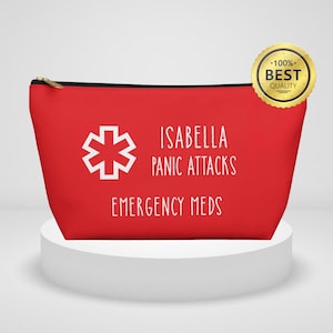 Może przedstawiać: Czerwona kosmetyczka z zamkiem błyskawicznym, białym tekstem i białym symbolem medycznym. Tekst brzmi "ISABELLA PANIC ATTACKS EMERGENCY MEDS". Złota naklejka z napisem "100% BEST QUALITY" znajduje się w prawym górnym rogu.