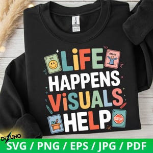 Peut inclure: Sweat-shirt noir avec l'inscription "LIFE HAPPENS VISUALS HELP" en lettres colorées. Le motif comprend des éléments graphiques tels qu'un smiley, une personne en pause, un crayon et un panneau stop. Le sweat-shirt porte également l'inscription "SVG / PNG / EPS / JPG / PDF".
