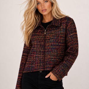 May include: A long-sleeve jacket featuring a multicolored tweed fabric with a textured weave of black, red, blue, and yellow threads. The jacket has a classic collar, a full-length front zipper closure with a metallic pull, and straight cuffs.