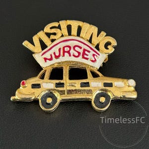 May include: A gold-toned vintage brooch featuring a car design with the words "VISITING NURSES" in gold lettering above a red and white banner. The car has black wheels and windows. A classic collectible.