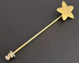 Broche de solapa minimalista con forma de estrella y flor en tono dorado vintage.