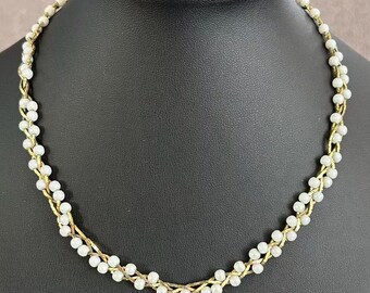 Collar vintage tejido con perlas de imitación y cadena trenzada en tono dorado.