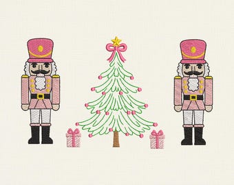 Può includere: Un design natalizio ricamato con due schiaccianoci rosa e bianchi, un albero di Natale verde con ornamenti rosa e due regali confezionati. Il design include il testo "6 Sizes" e le misure.