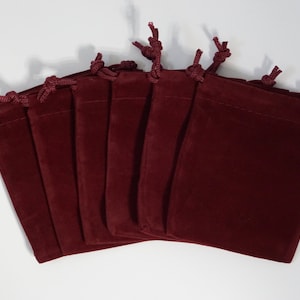 May include: A set of eight burgundy velvet drawstring pouches with a red cord.