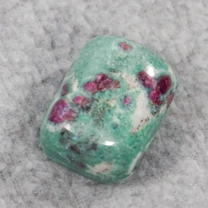 May include: A green and pink tumbled stone with a smooth, polished surface. The stone has a mottled pattern of green, white, and pink.