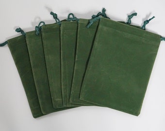 May include: Six green velvet drawstring pouches with green drawstrings. The pouches are folded and stacked on top of each other.