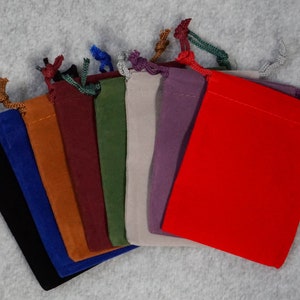 May include: Assortment of ten small velvet drawstring bags in various colors, including black, blue, orange, brown, burgundy, green, gray, purple, and red.